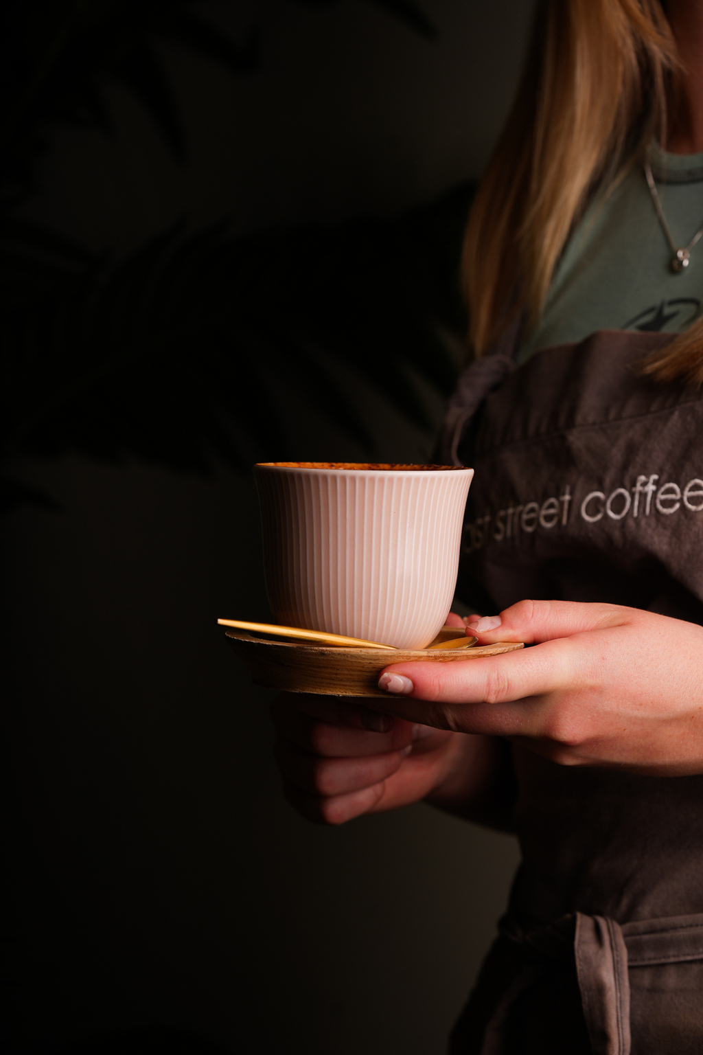 A barista holding a Poached cup